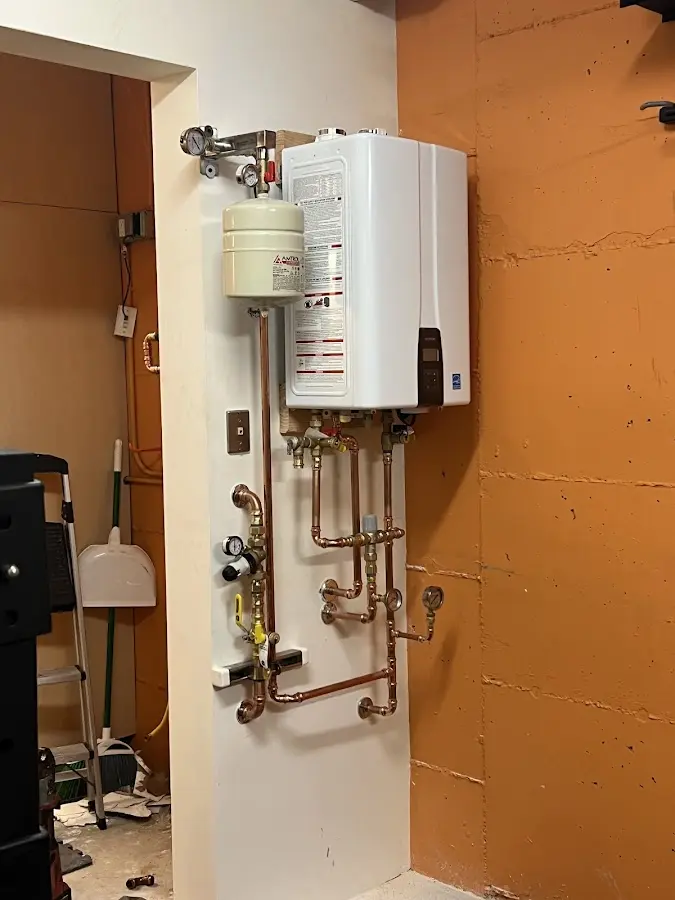 Plumbing technician inspecting water heater connections in South Londonderry